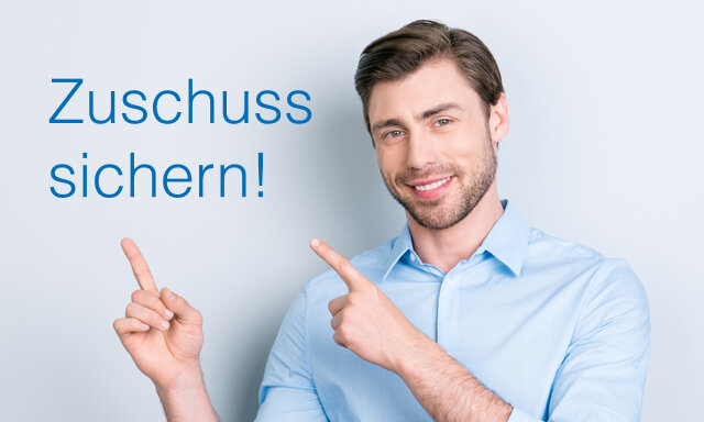 Ein lächelnder Mann mit braunen Haaren und Bart trägt ein blaues Hemd. Er zeigt auf die Worte: „Zuschuss sichern!“.