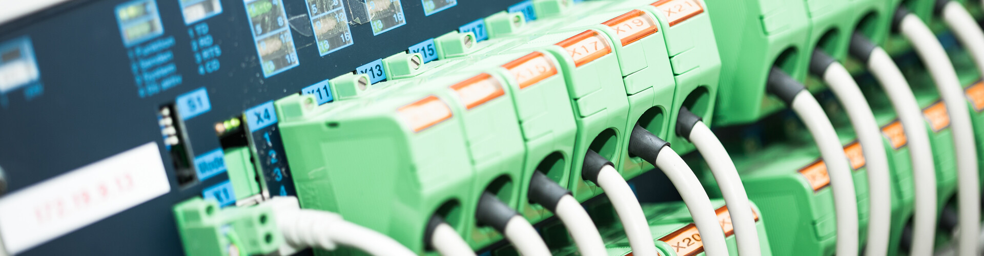 Grüne Kabeleinführungen mit Anschlussöffnungen in einem Baustromverteiler, beschriftet mit Identifikationsnummern.