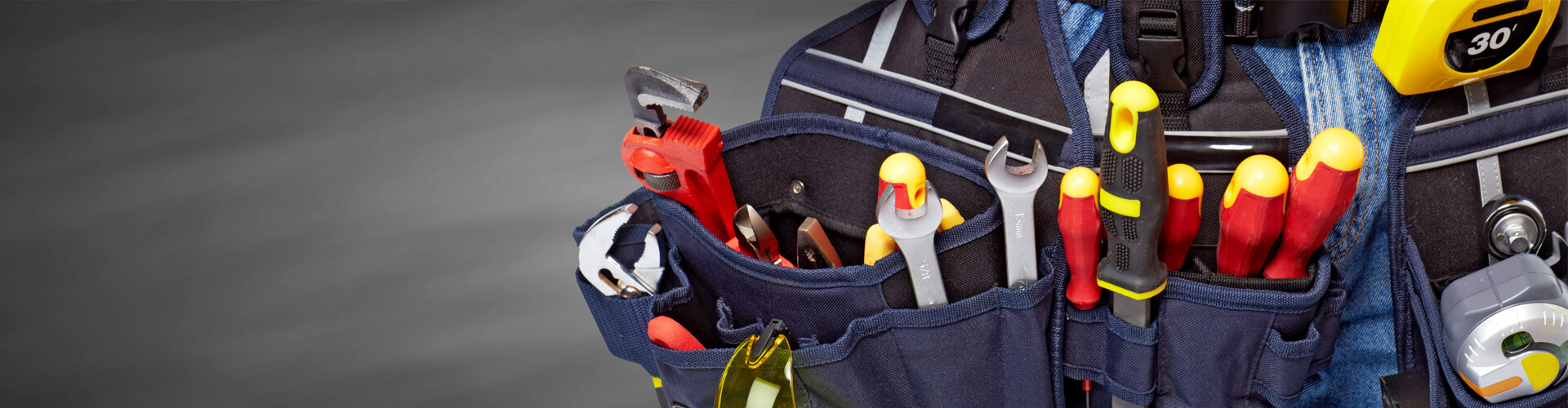 Eine geöffnete Handwerkertasche mit einer Vielzahl an Werkzeugen.