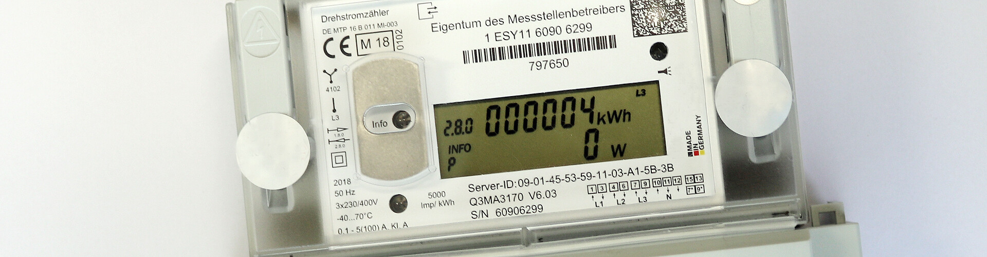 Auf einem digitalen Zähler ist ein Display zu sehen, auf dem 4 Kilowattstunden angezeigt werden. Der Zähler ist weiß. Neben der Aufschrift "Eigentum des Messstellenbetreibers" sind zudem zahlreiche technische Angaben auf dem Gerät vermerkt. 